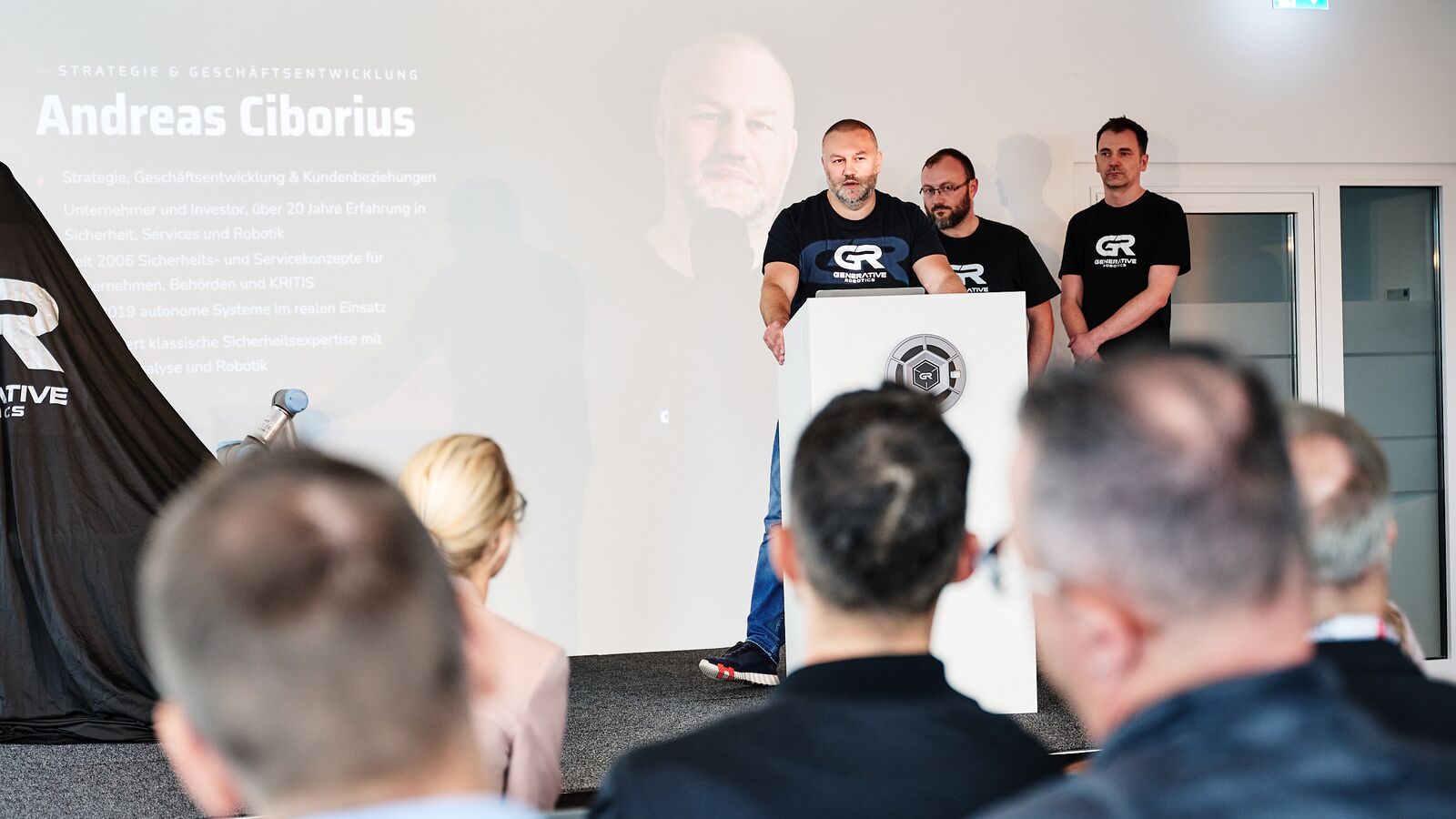 Andreas Ciborius am Rednerpult vor seiner Namensfolie, hinter ihm Aleksej Tokarev und Thomas Schröter